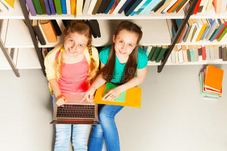 两个微笑的女孩在图书馆的上方画像