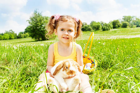 公园里坐着的女孩和可爱的兔子