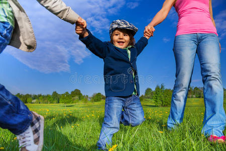 公园里牵着父母的手快乐的孩子
