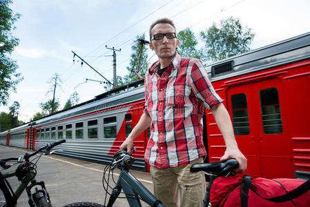 带着自行车和行李的游客在市郊铁路站台上等候