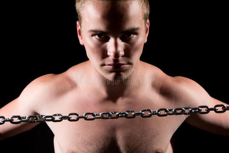 一个戴着金属链的肌肉男的特写肖像。