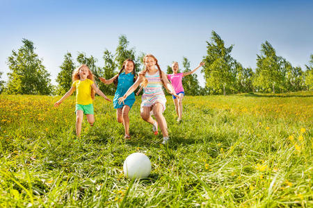 一群孩子跑到草地上的球