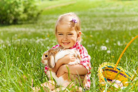 小女孩在田里拥抱兔子