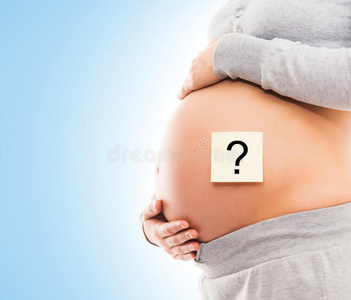 一个年轻孕妇的腹部贴着白色的贴纸