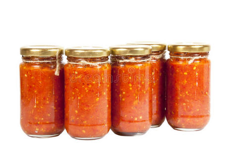 一瓶瓶鲜红色辣椒酱被称为maz带橄榄油和盐罐的瓶子.