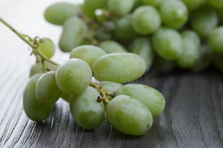 黑木桌上成熟的绿葡萄