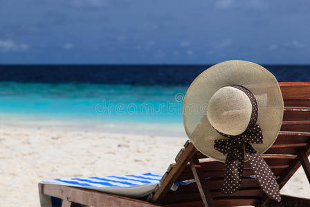 热带海滩躺椅上的草帽