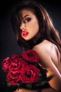 美丽的女性持有情人节红玫瑰花束