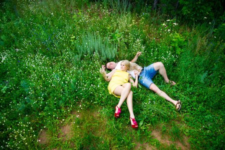 恩爱夫妻躺在绿色草地上，在夏天