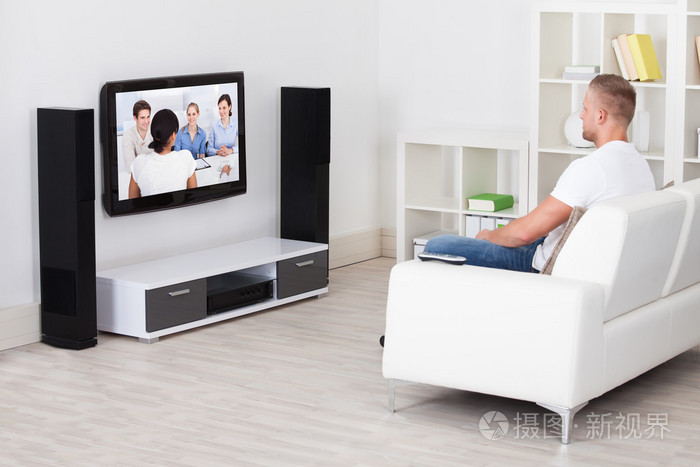 他看电视的客厅里的沙发上坐着的人照片-正版商用图片1f7jkb-摄图新