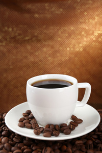 咖啡豆和杯咖啡上棕色背景表格