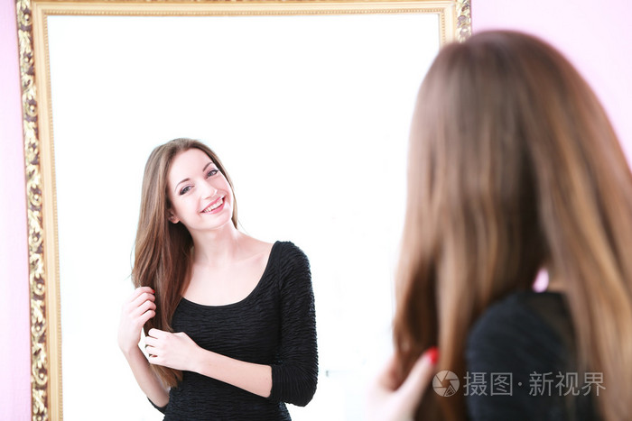 年轻漂亮的女人站在前面的房间里的镜子照片-正版商用图片1f7lvt-摄图