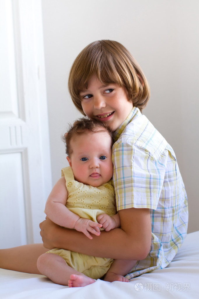 小男孩抱着他刚出生的妹妹