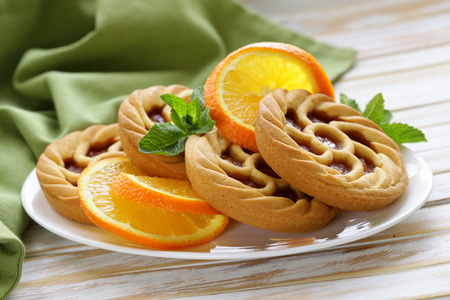 用木制的桌子上的橙色迷你甜点挞