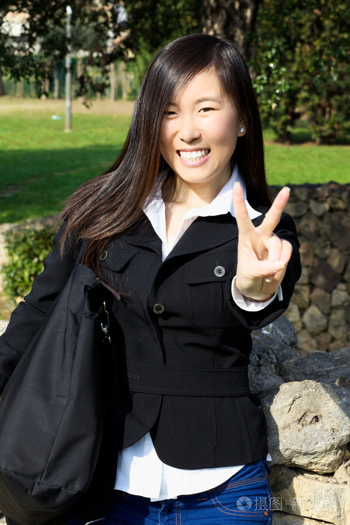 胜利的手势快乐微笑的亚裔美国女孩