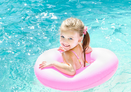 微笑在泳池中的小女孩