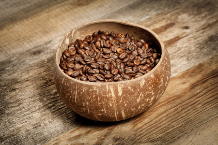 木制的桌子上的咖啡豆的木杯