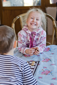 美丽笑小女孩在玩跳棋