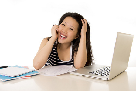 幸福中国的亚洲女人，她在白色背景上的笔记本电脑上工作