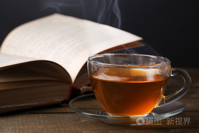 喝杯热茶在深色背景上桌上的书