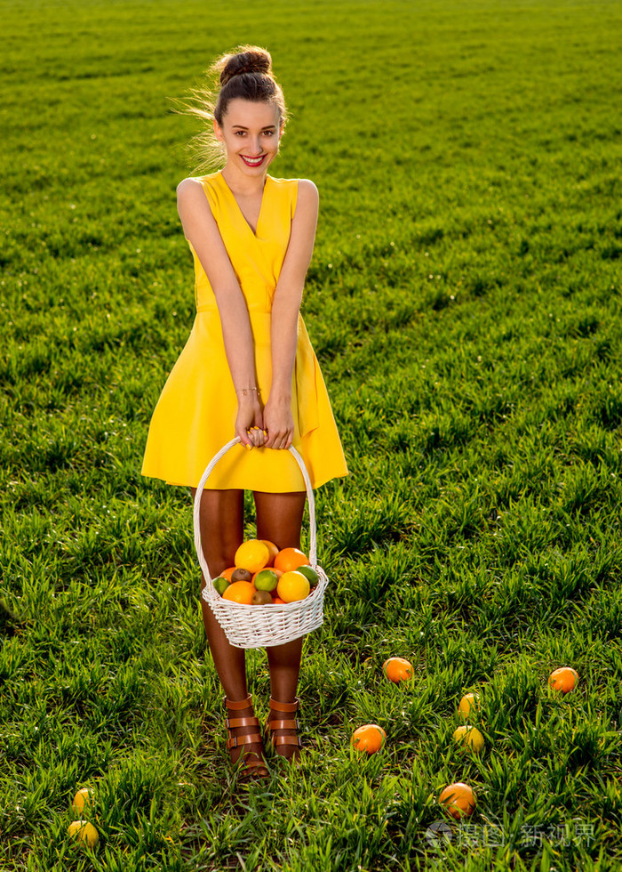 提着篮子装满水果对格林菲尔德的微笑的年轻女子