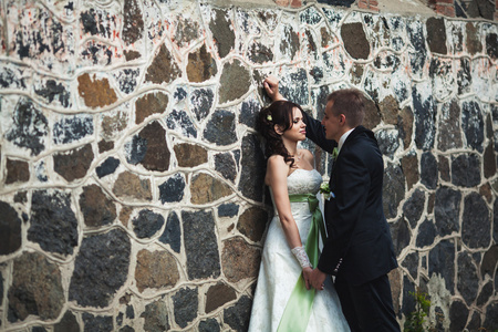 婚礼。丈夫和妻子在石头墙背景上