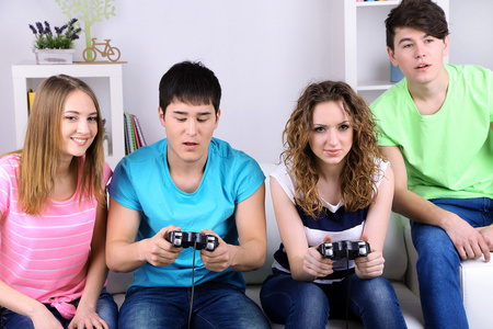 群年轻朋友玩视频游戏在家里