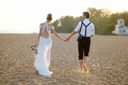 新娘和新郎在日落时的海滩上