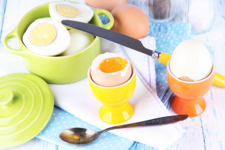 煮熟的鸡蛋在潘和摆设颜色木制背景上