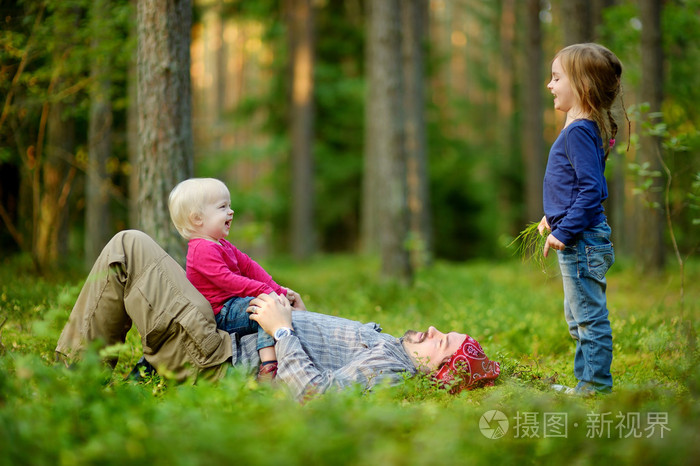 年轻的父亲和他的两个小女儿