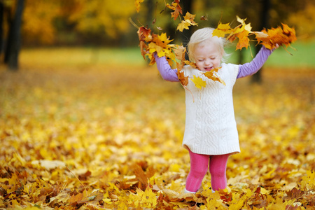 可爱的蹒跚学步的女孩画像上秋季的一天