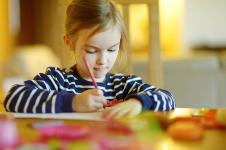 可爱的小女孩用铅笔绘图