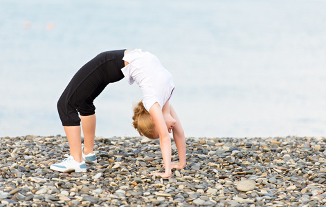 在海滩上的瑜伽和体育锻炼的女人
