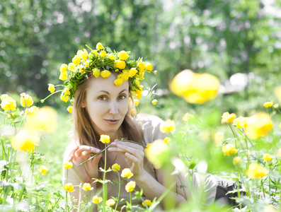 年轻漂亮的女人在一个花圈从金莲花天然领域