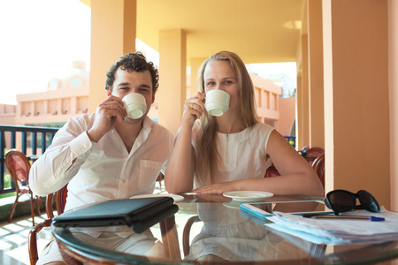 年轻的夫妇在阳台上喝咖啡