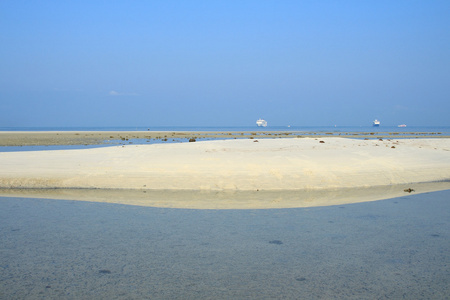 白色沙滩，亮蓝色的大海和天空