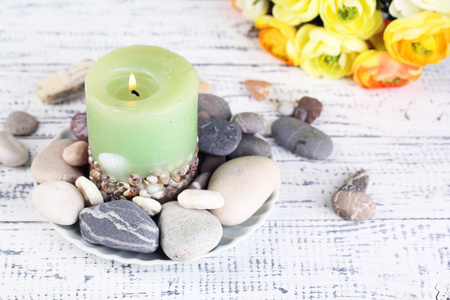 spa 石块 蜡烛和鲜花颜色木制的桌子，在明亮的背景上的组成