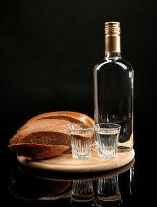 瓶伏特加，新鲜的面包和木板，孤立的黑色的眼镜