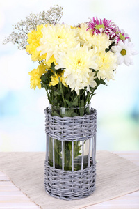 在明亮的背景上桌上花瓶美丽菊花