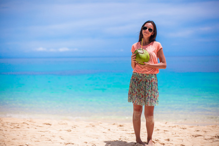 可爱的年轻女子，与热带海滩上椰子