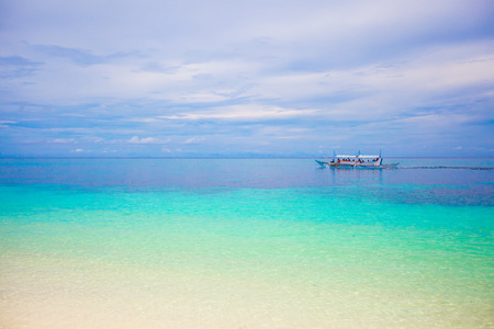  精益碧绿的水，小船在热带岛附近的海面