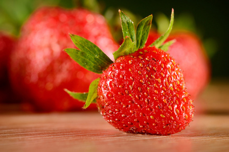 张木桌上的美味草莓的照片