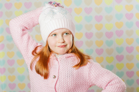 小女孩在一顶粉红色的帽子和一件毛衣