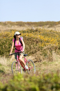女人骑自行车由海洋海岸