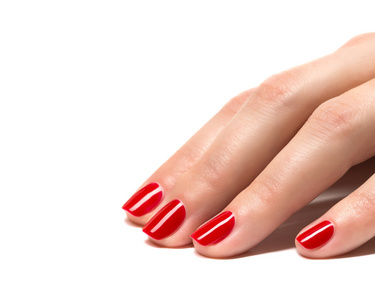 修剪整齐的红色的女人双手的指甲特写。皮肤和指甲护理