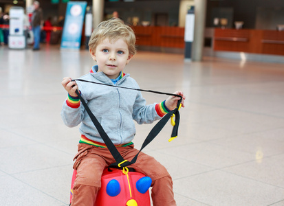 你打算在假期旅行的行李箱在机场班车的有趣幼儿男孩
