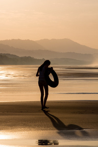 一个女孩走在沙滩上的剪影