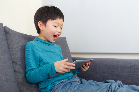 亚洲的小男孩感到兴奋使用平板电脑