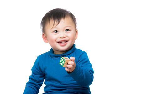 亚洲宝贝男孩微笑着对木制玩具块