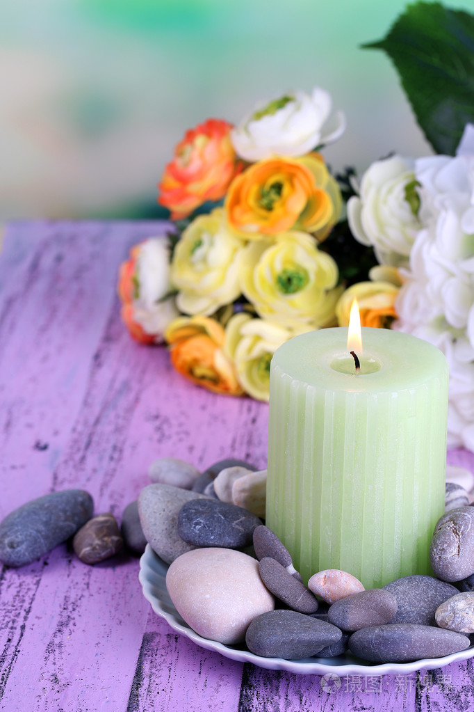 spa 石块, 蜡烛和鲜花颜色木制的桌子,在明亮的背景上的组成